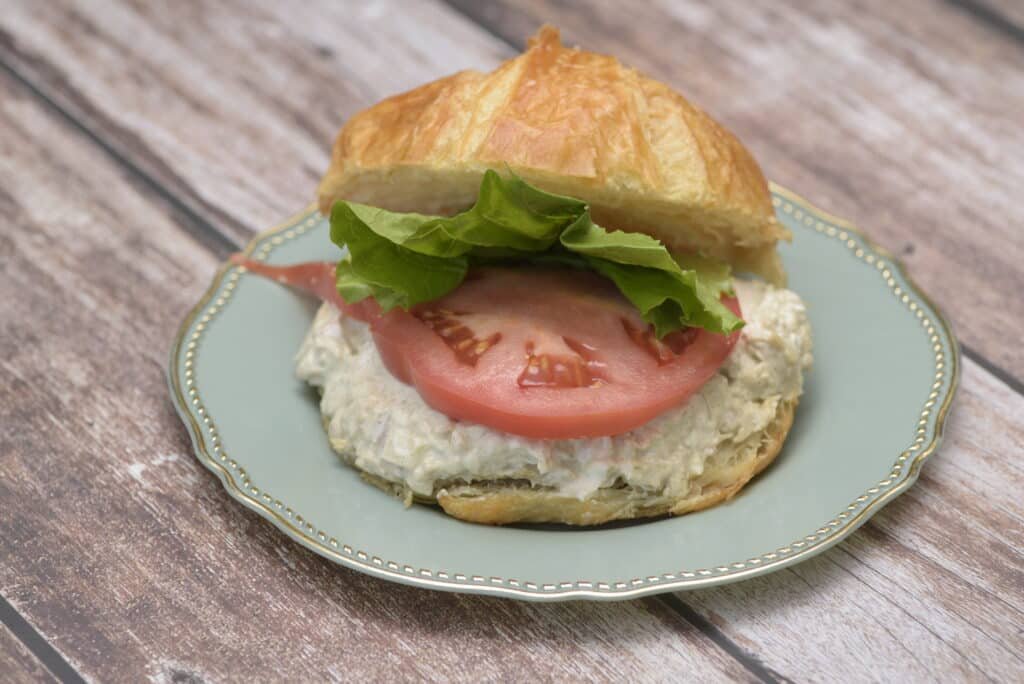 tuna salad with tomato and lettuce on croissant
